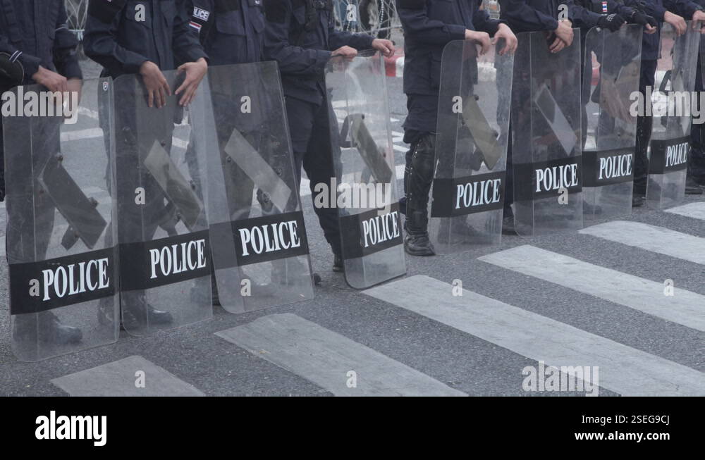Riot policemen with shields standing in line on street Stock Video ...