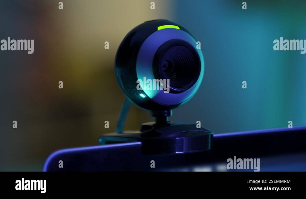 Extreme close up on webcam camera on computer screen or laptop as it ...