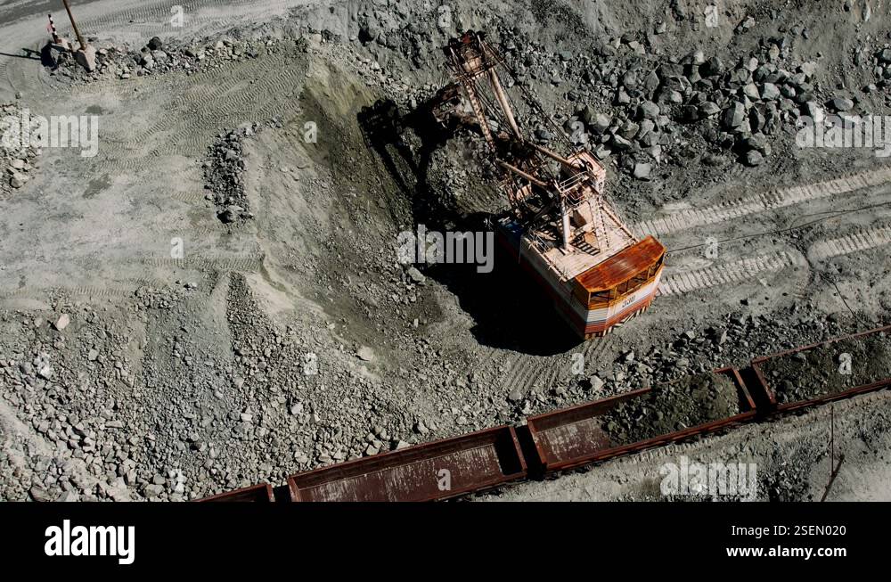 Excavator load the minerals and rock into freight cars. Mining industry ...