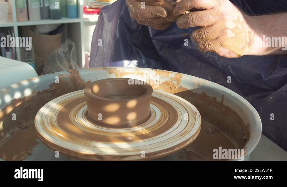 man potterist making bowl on a potters wheel from clay in a ceramic ...