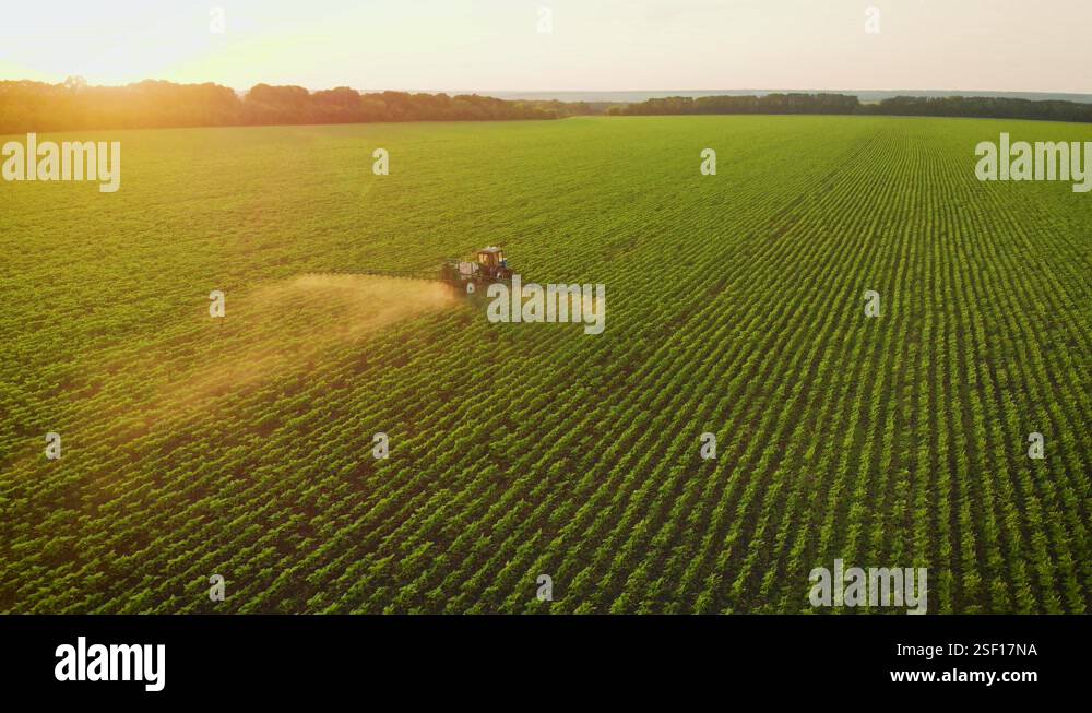 Aerial view of farming tractor spraying on field with sprayer ...