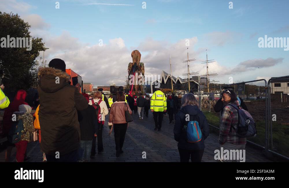 Wide shot of people walking behind Storm the Giant puppet Stock Video ...