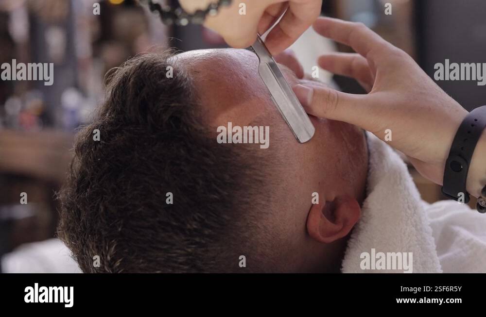 Barber haircut hair with straight edge razor, barber makes haircut for ...