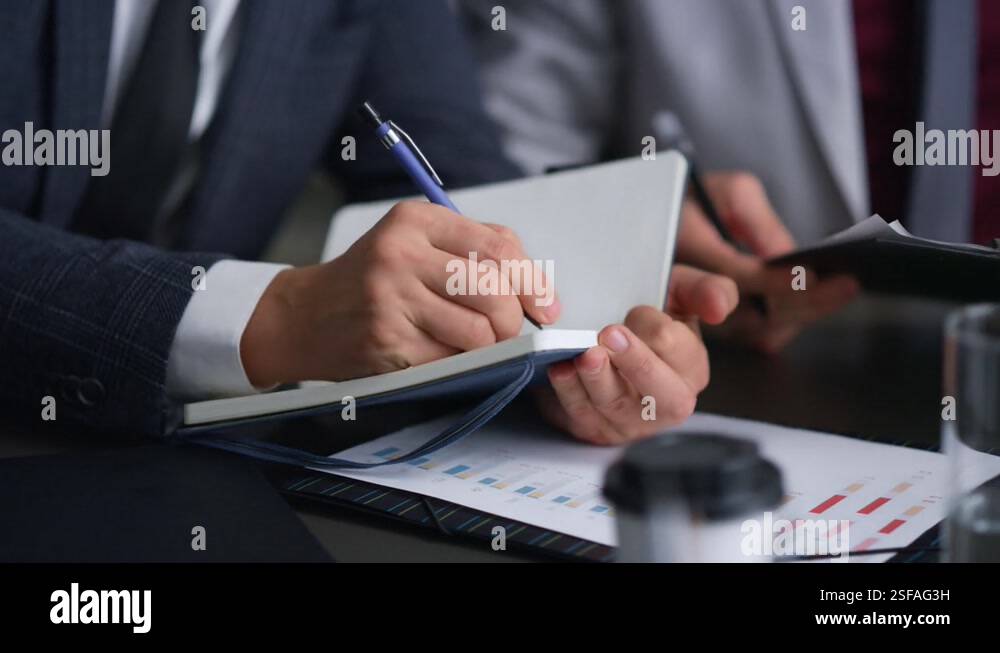 Lawyers team hands writing notes filling paperwork in business meeting ...