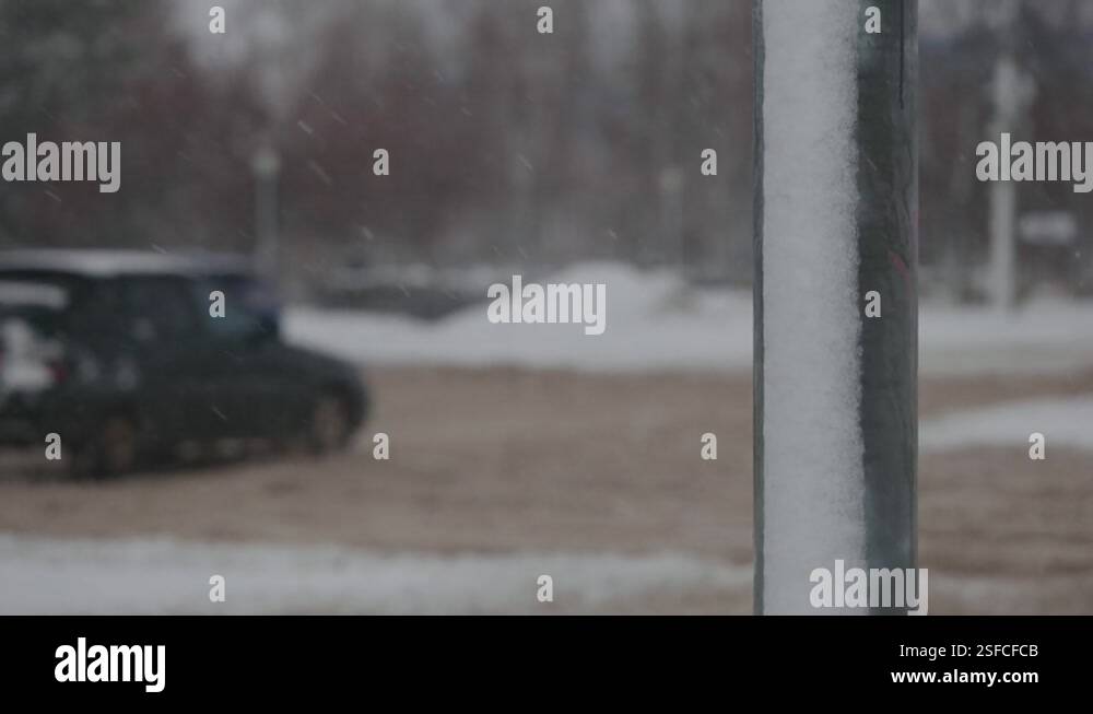City roads during heavy snowfalls. Cars drive through winter mud and ...