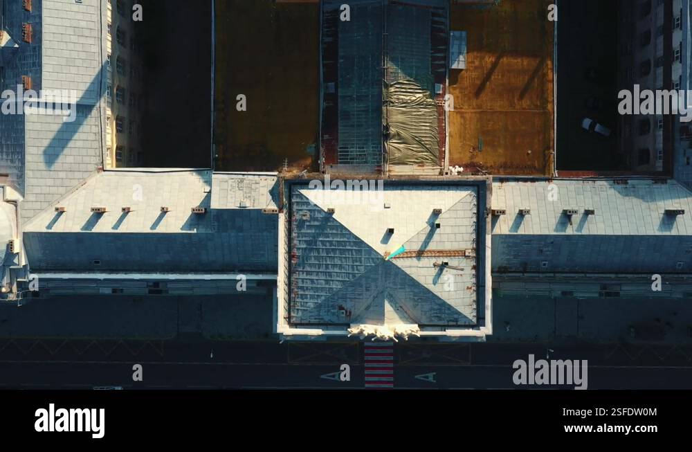 Drone flying low directly above old historic buildings, rusty rooftops ...