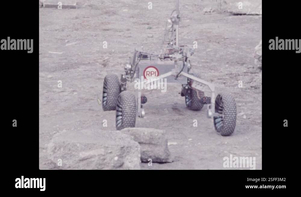 1970s: Robotic vehicle driving across dirt, around rocks. Rover ...