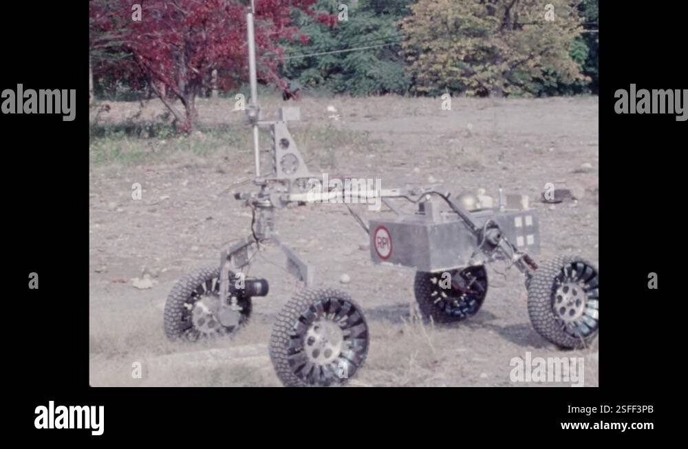 1970s: Robotic vehicle driving over dirt, rocks. Rock stopping rover ...