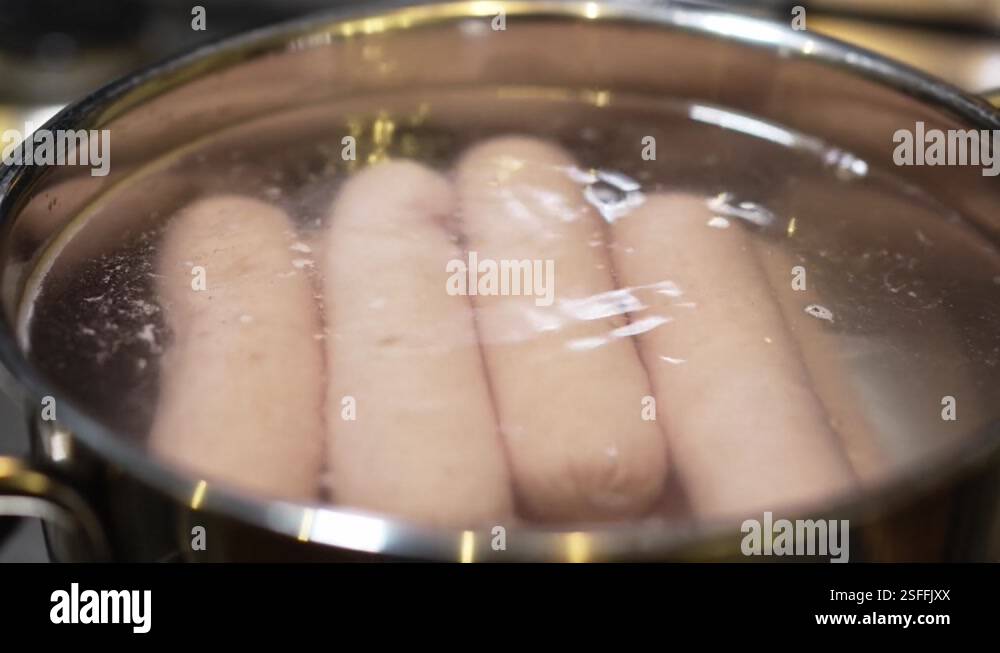 Boiling Susage sausages in boiling water in a saucepan on the burner of the gas stove ...