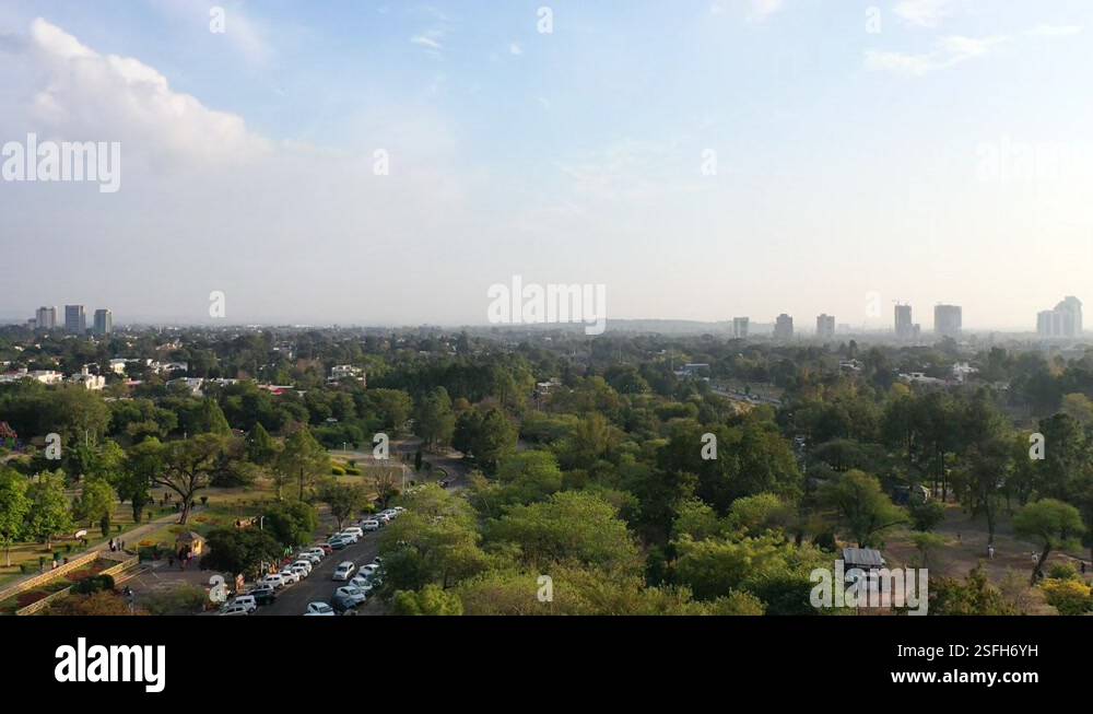 Aerial Rising Aerial Rising Out Of A Park To View A Sprawling City On A Hazy Morning ...