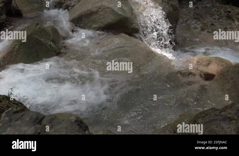 Closeup of water flow over rocks. Clean water flows over the rocks into ...