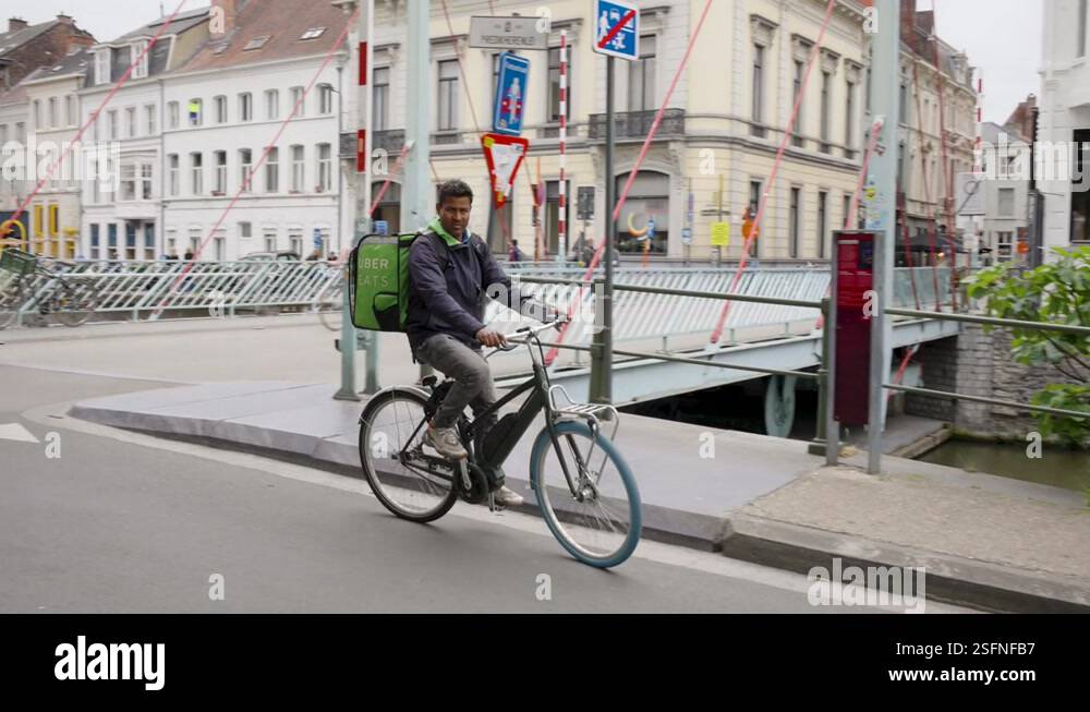 Uber Eats delivery rider cycling in the urban city center, Deliveroo ...