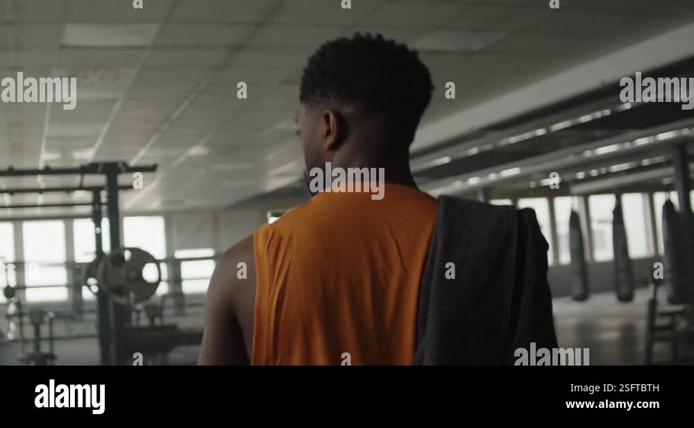 Young black male entering the empty gym ready to start his workout ...