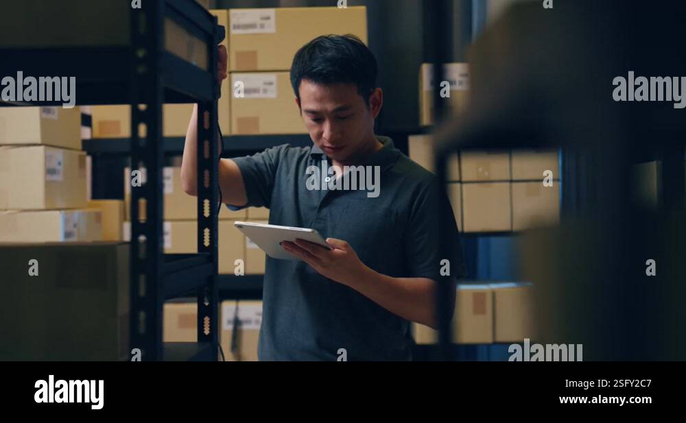 Asian man use barcode scanner scan paper box and put data in digital ...