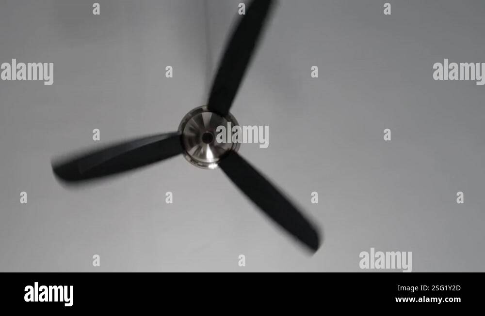 Minimalist interior. Spinning air cooling ceiling fan. Grey background ...