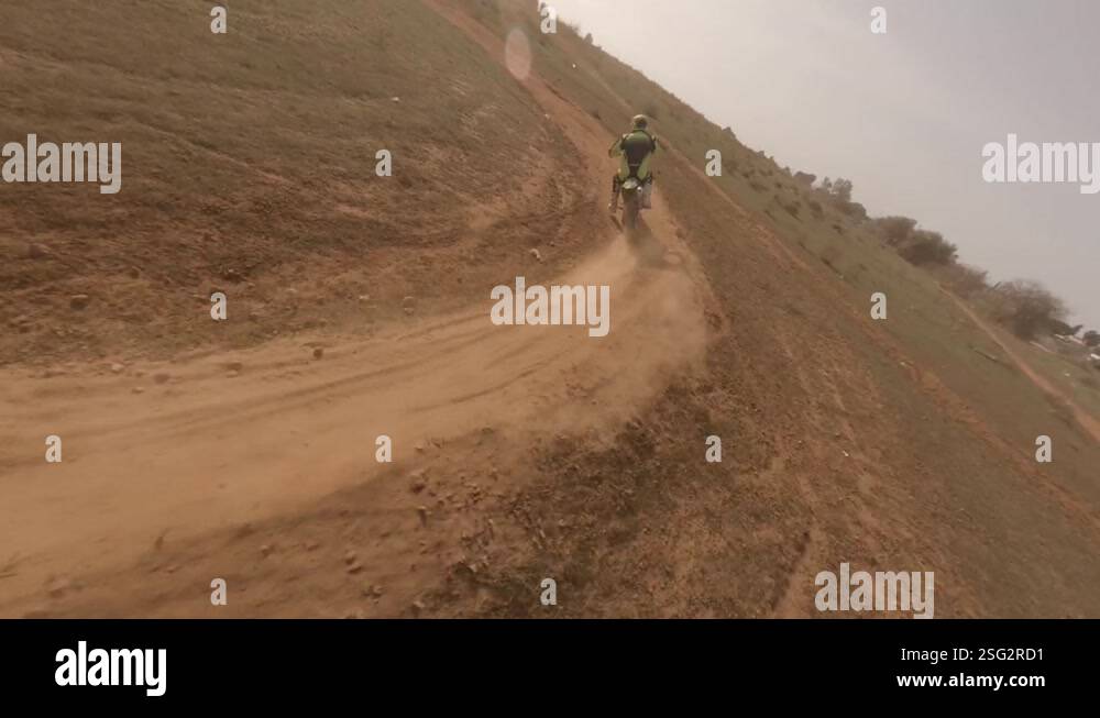 Fast FPV drone catches up to motorcycle moto racer on sandy dirt track ...
