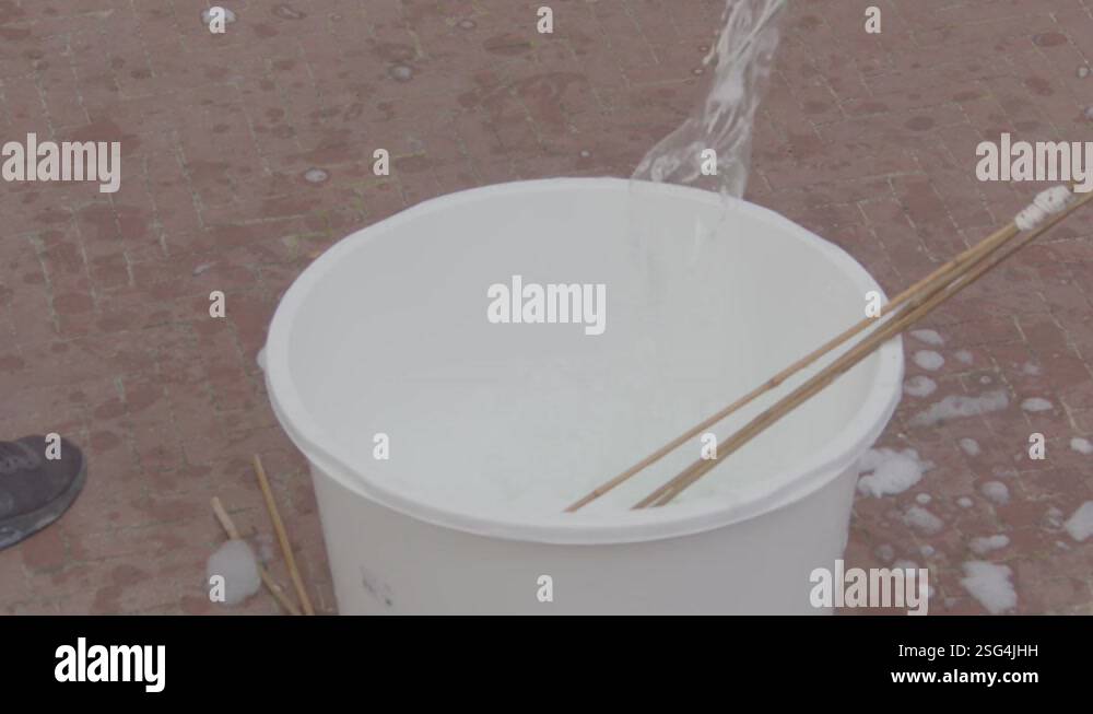 Stick with rope being pullet out of bucket of water and making a small ...
