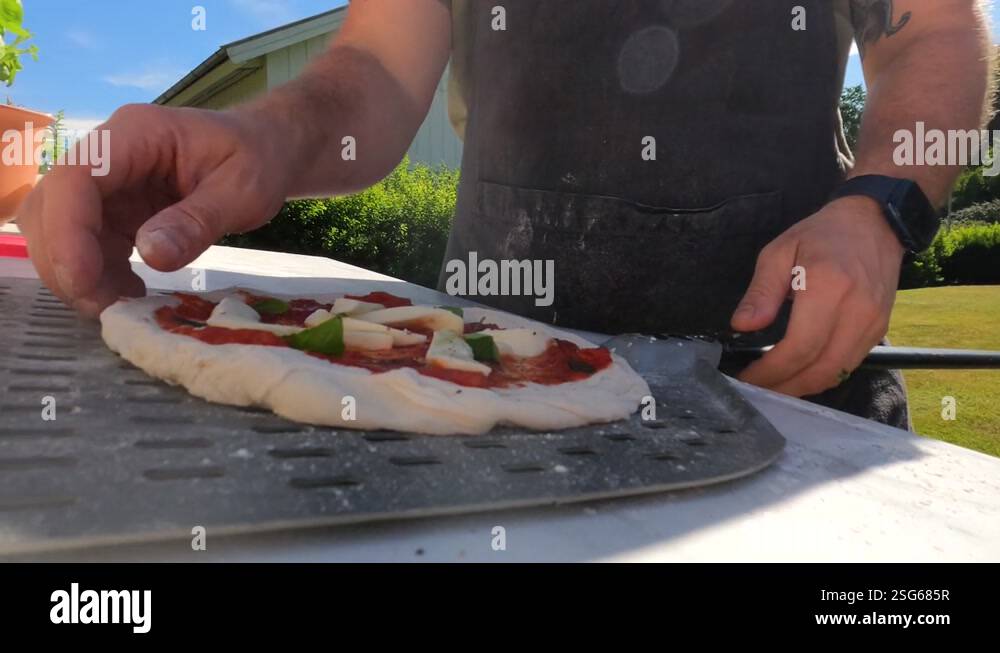 4k Shot of a male chef stretching his home made italian style pizza ...