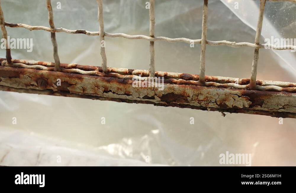 Old rusty gate surface on construction site, worker removing rust and ...