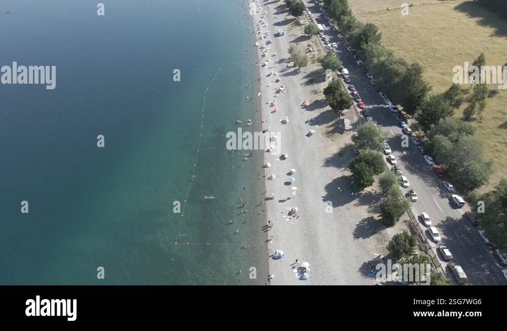 Aerial view of the Ranco lake in chile with people on it, a paved road ...