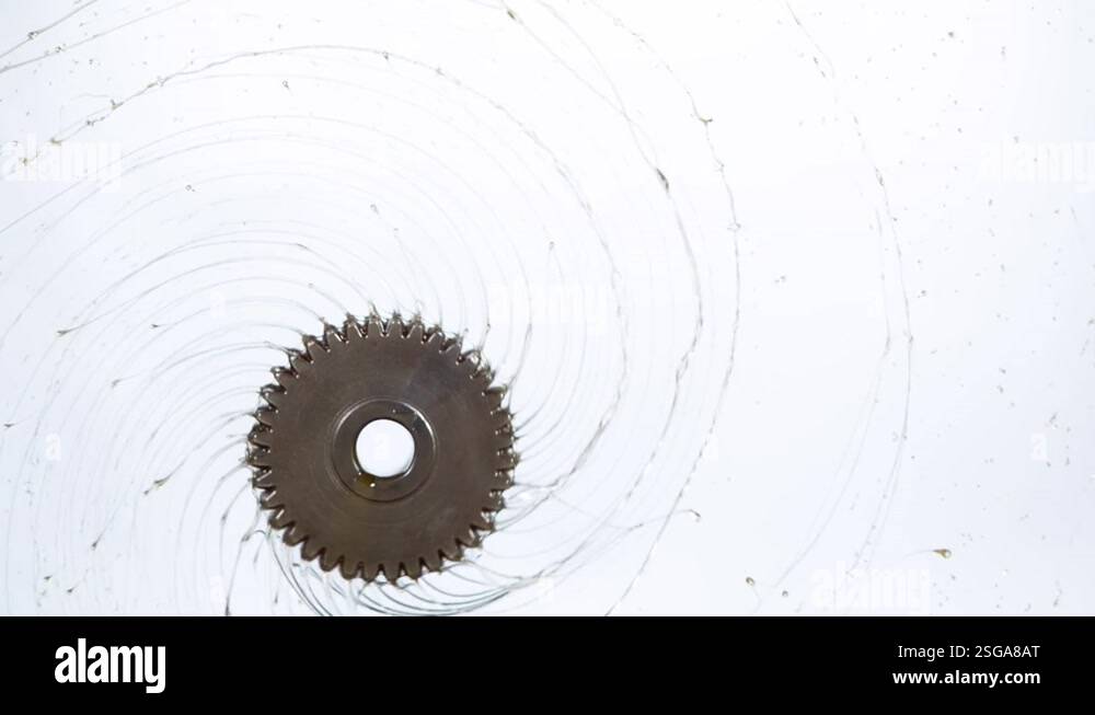 Super slow motion of rotating engine steel wheel with oil splashes on ...