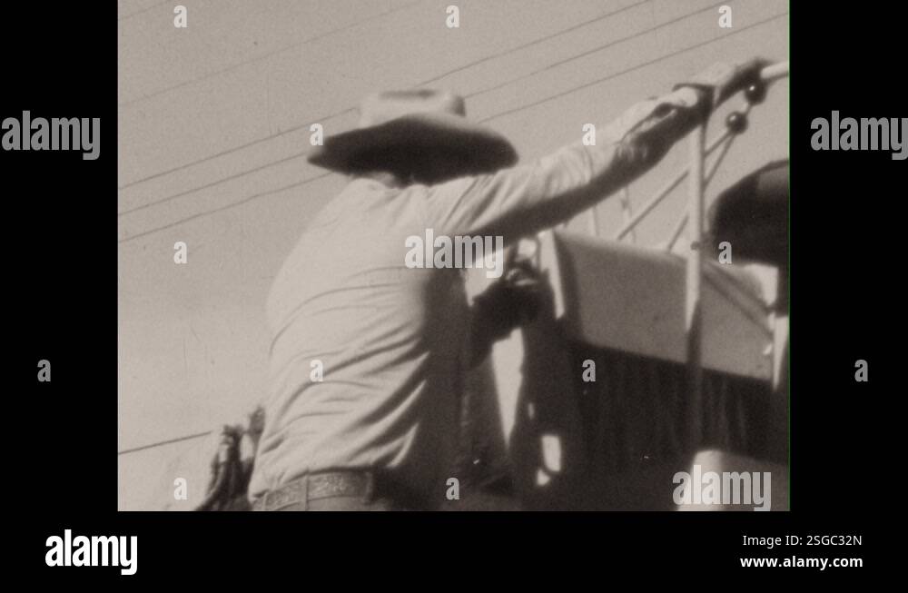 1960s: Girls sit on truck bed, dangle legs, watch. Man climbs up onto ...