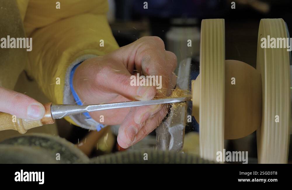 Slow motion, close up: carpenter using chisel for shaping piece of wood ...