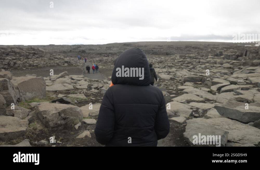 People walking along path with large rocks in rural Iceland with gimbal ...