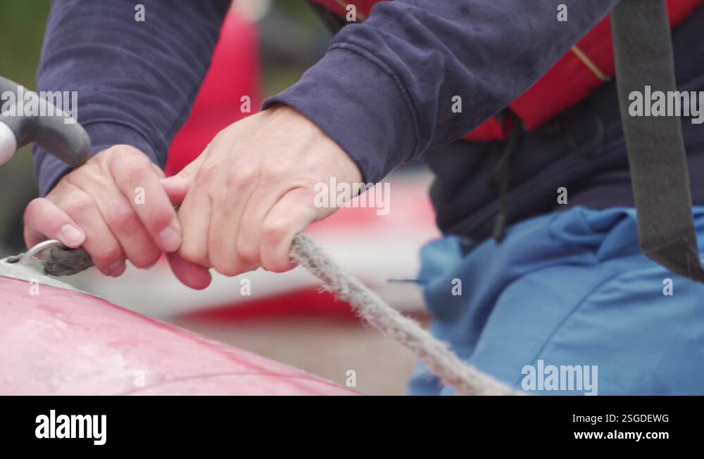 The rafter is holding a safety rope on the raft during a whitewater ...