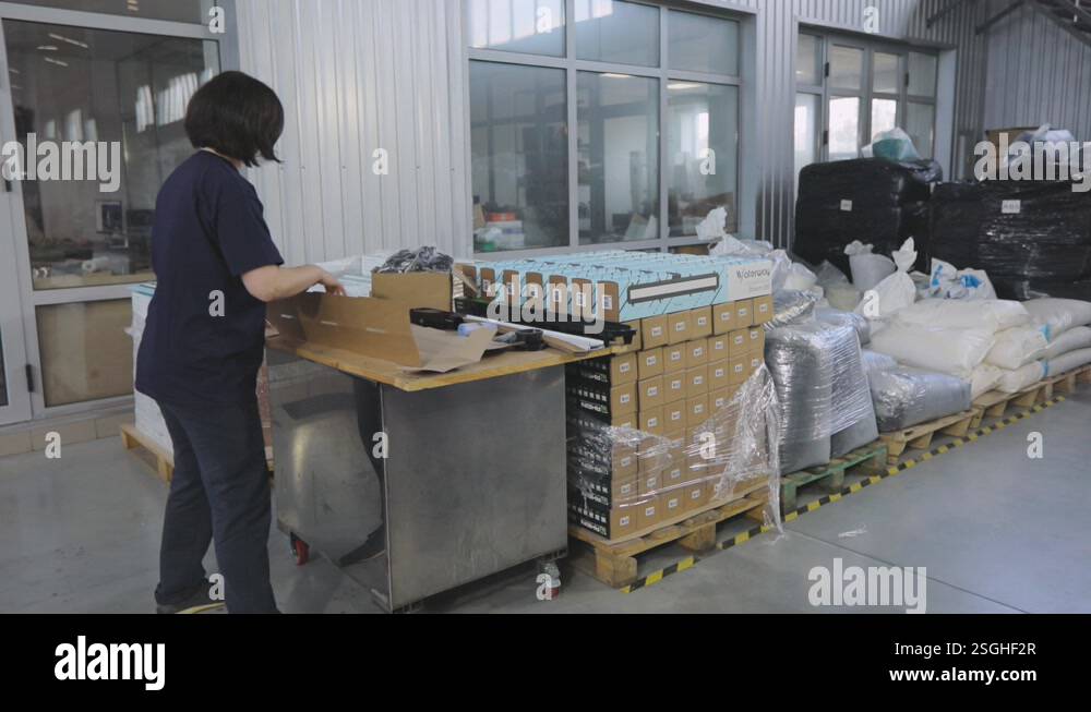 Packaging of finished goods in a box. Workers pack finished products ...