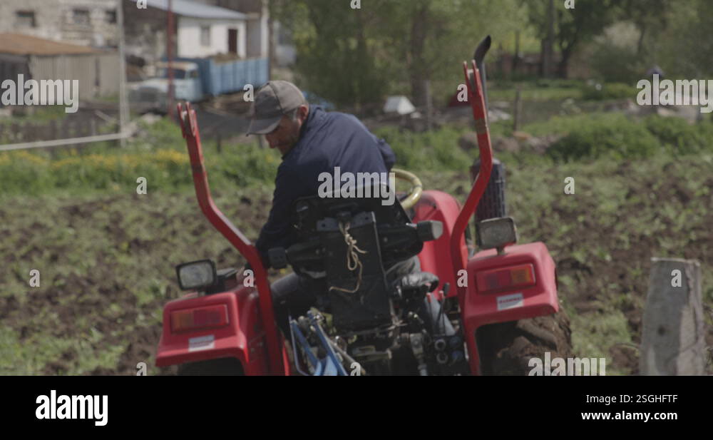 A Farmer Driving Vintage Agricultural Tractor Plowing Fields In Stock ...