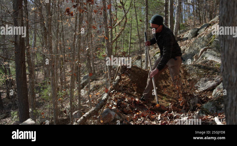 Mountain biker rakes leaves off of bike trail in autumn to ride bike Stock Video Footage - Alamy