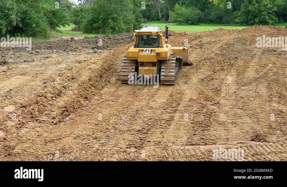 Large and powerful Caterpillar bulldozer pushing dirt up a slope to ...