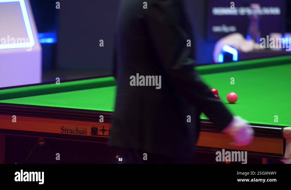 A professional snooker player is seen in action as he plays a shot ...