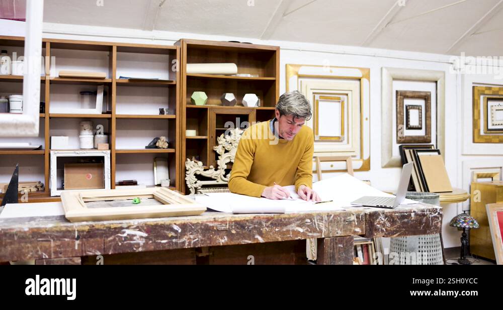 Frame maker leaning on work bench drawing frame sketch Stock Video ...