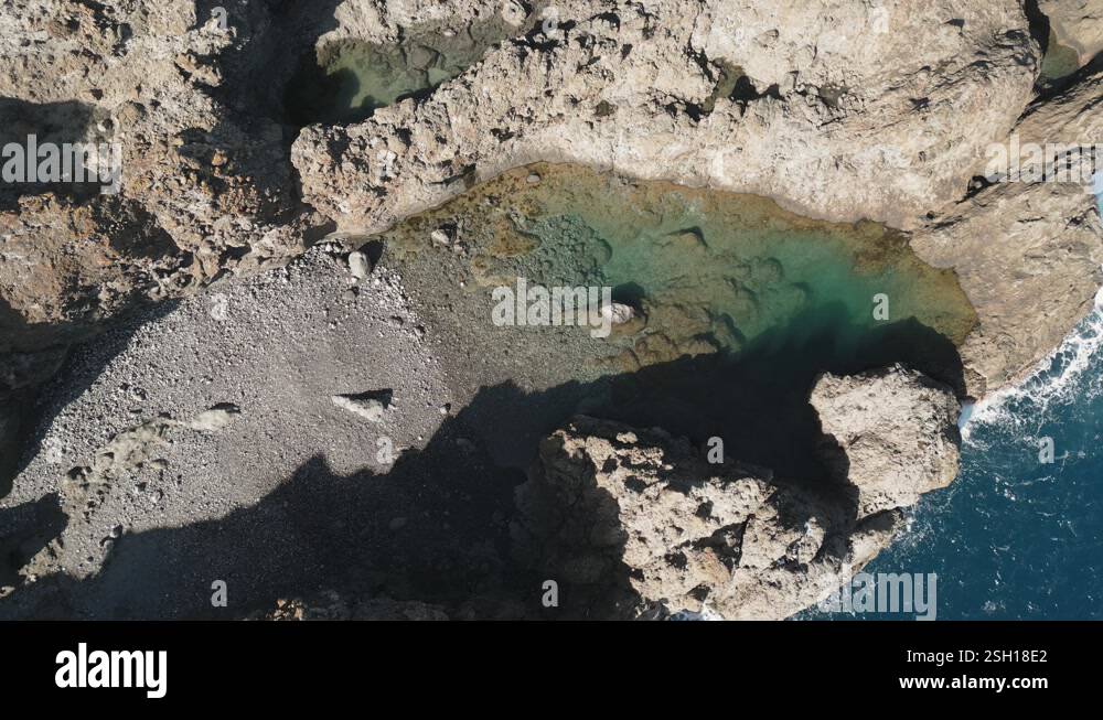 Aerial view a natural pool of turquoise water surrounded by volcanic ...