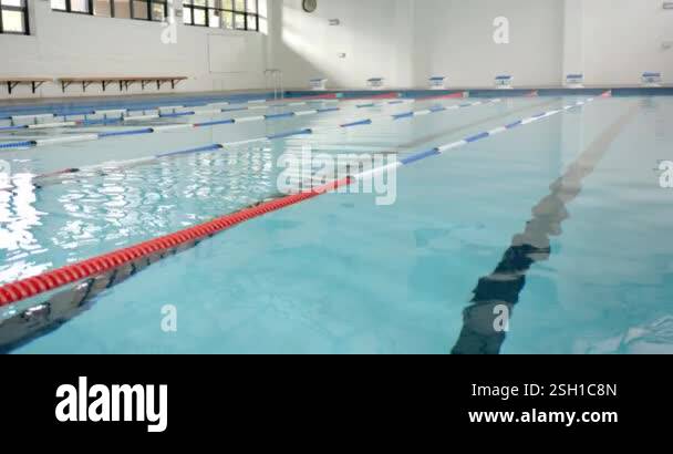 Empty indoor swimming pool with lane dividers, ready for swimmers to ...