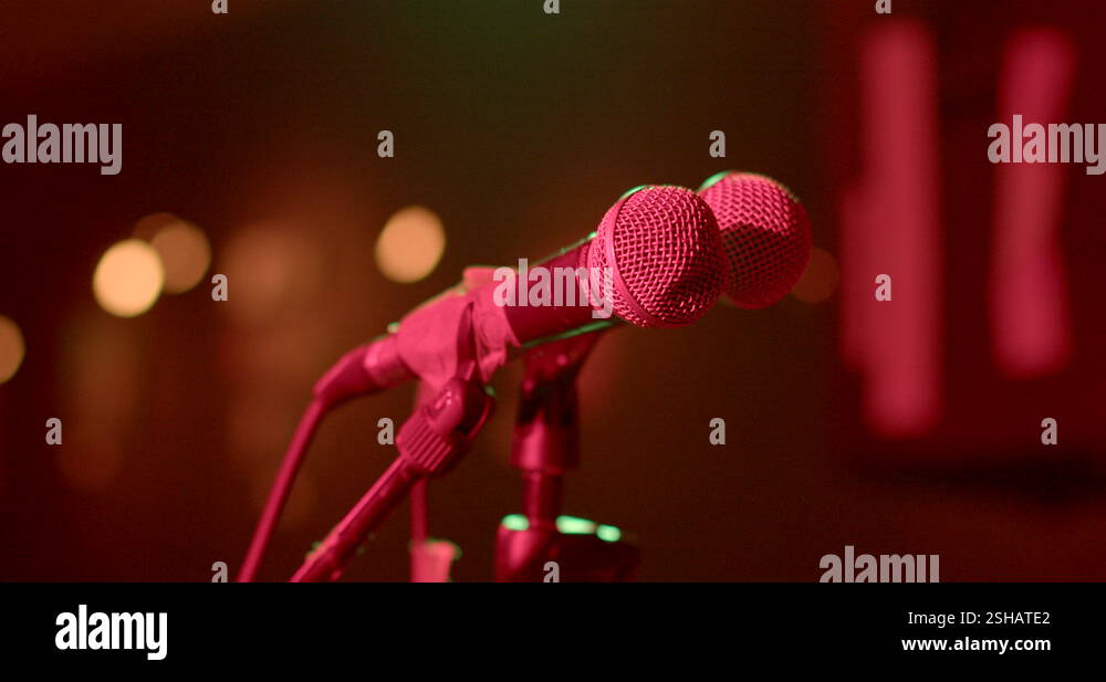 Microphones in red light on stage. They are tied with sticky tape Stock ...