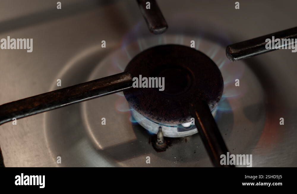 Top down close up view of old rusty gas stove, fire starts to burn ...
