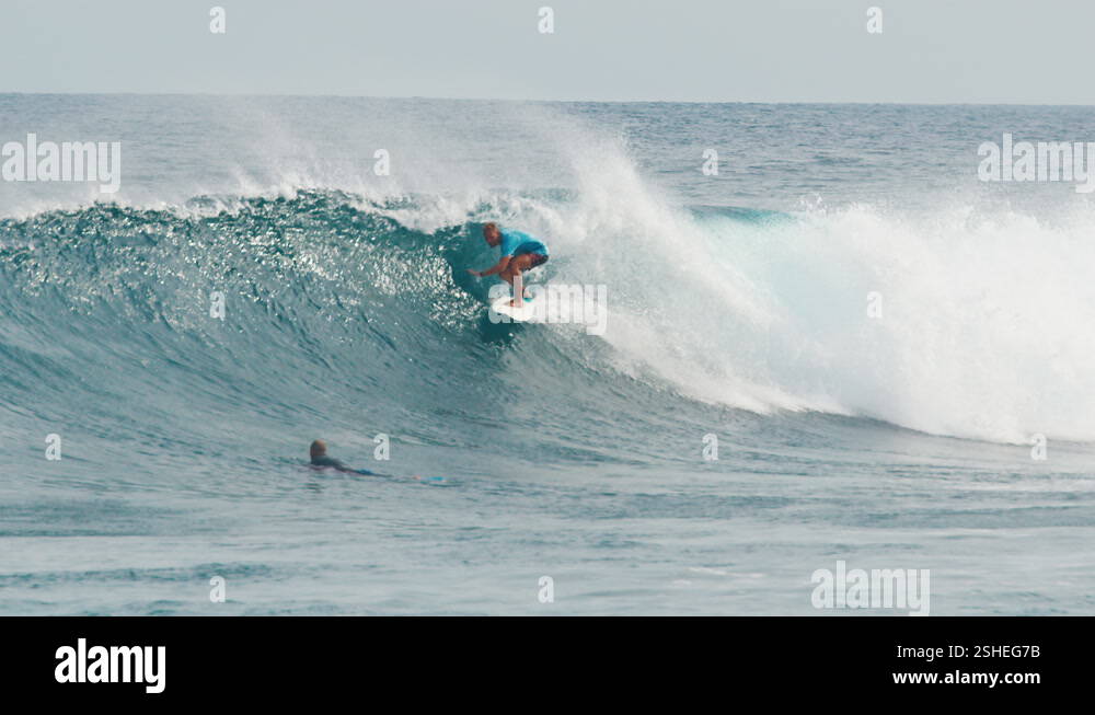 Surfer surfs the wave. Male surfer rides the wave in the Maldives Stock ...