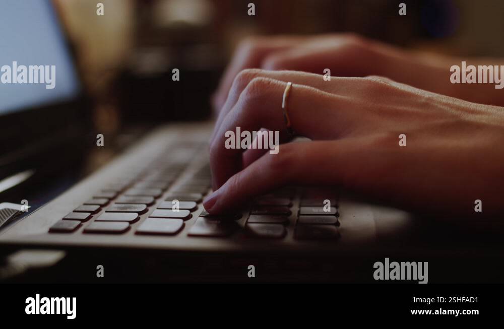Young woman with a ring typing a message on her laptop by home office ...