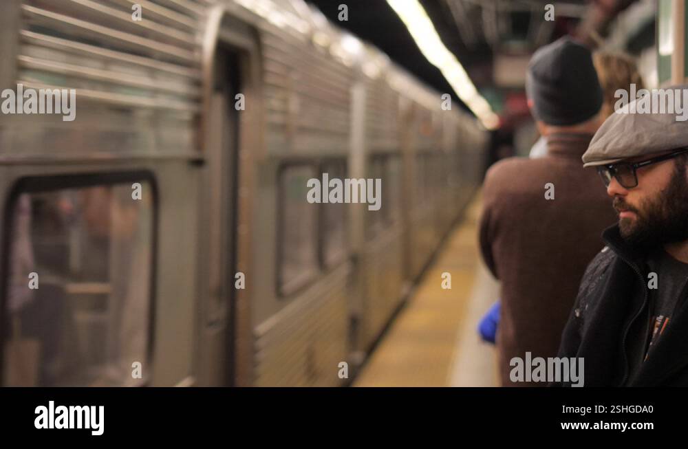 A man waits as a metro train passes by in slow motion Stock Video ...