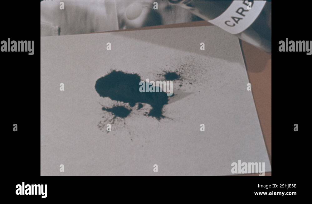 1950s: Lab. Man uses tool to dump carbon powder onto piece of paper ...