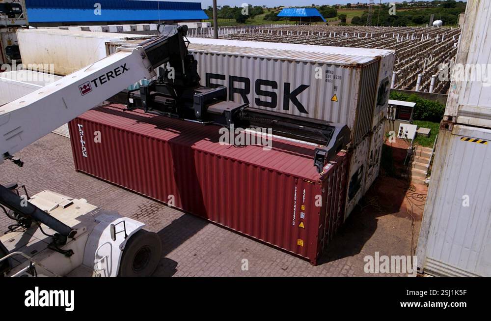 Crane releases shipping container after offloading, backs up, aerial ...