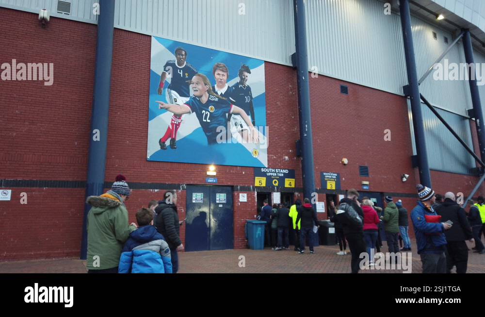 Fans go through security underneath a large mural of the great female ...