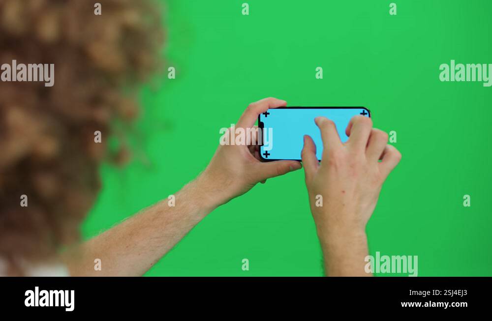 Young man uses smartphone, scrolls through the images and swipe across ...