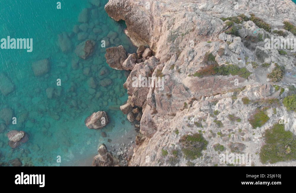drone captures birds eye of rocky cliff edge, as camera soars over ...