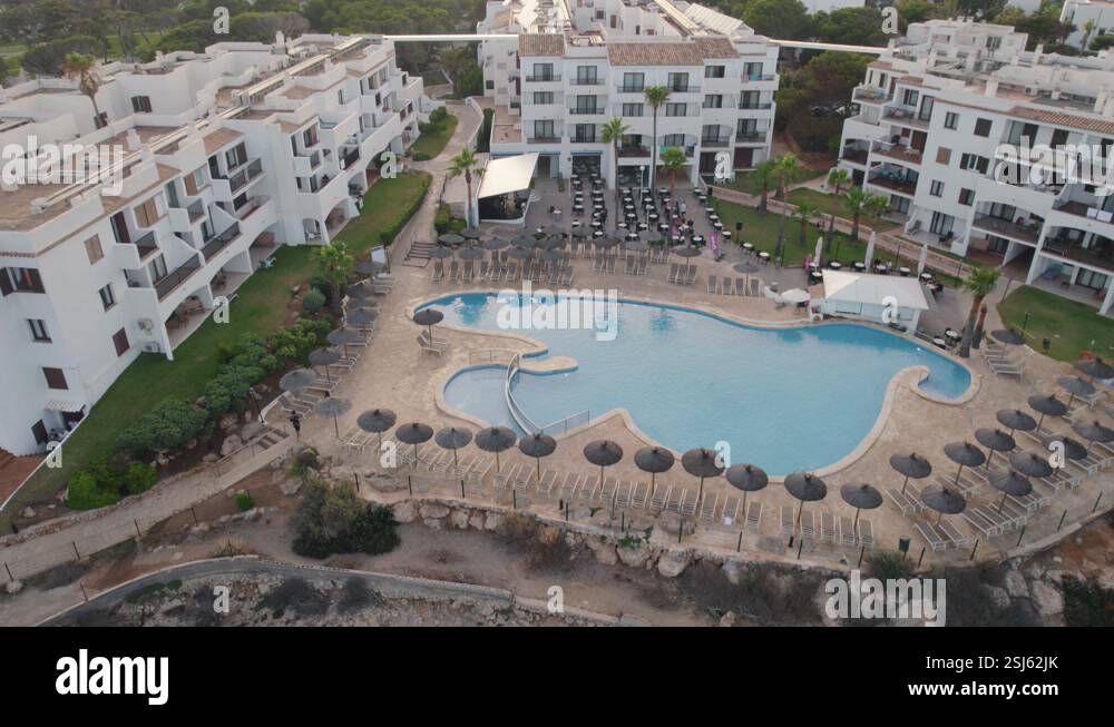 Aerial view of hotel buildings with a large swimming pool waiting for ...