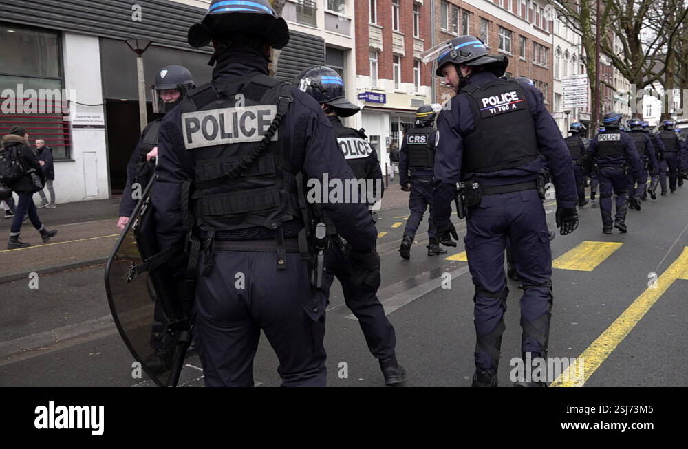 In slow motion a unit of riot police wearing helmets and carrying ...