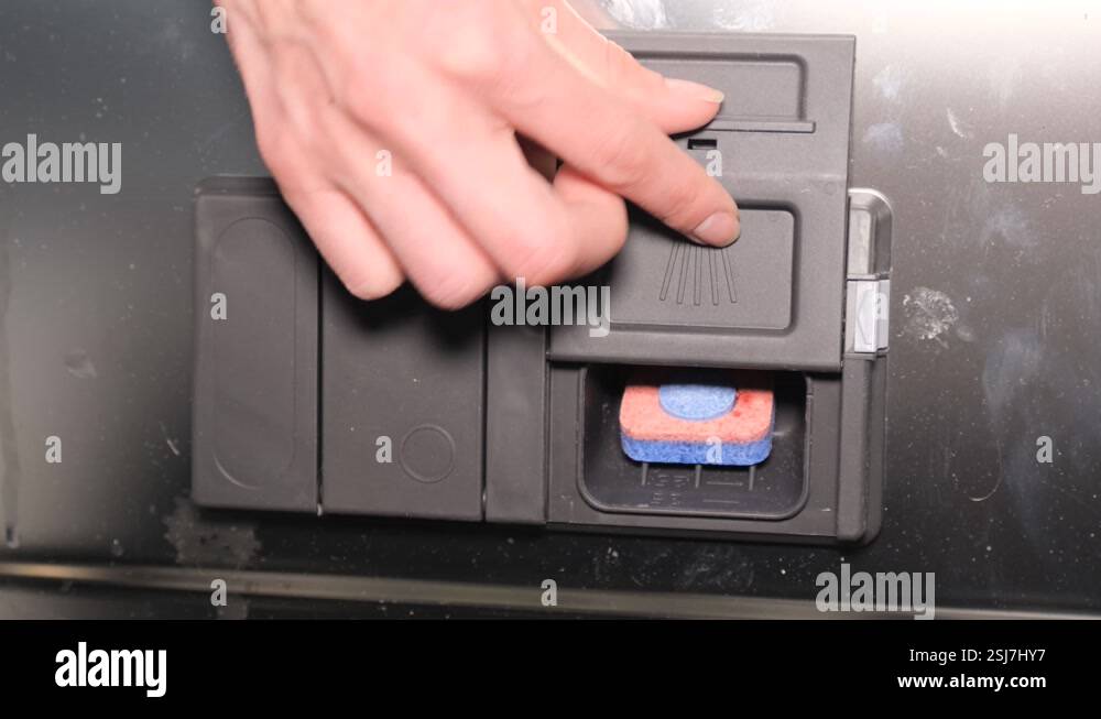 A woman's hand inserts a chemical tablet into the container of the ...